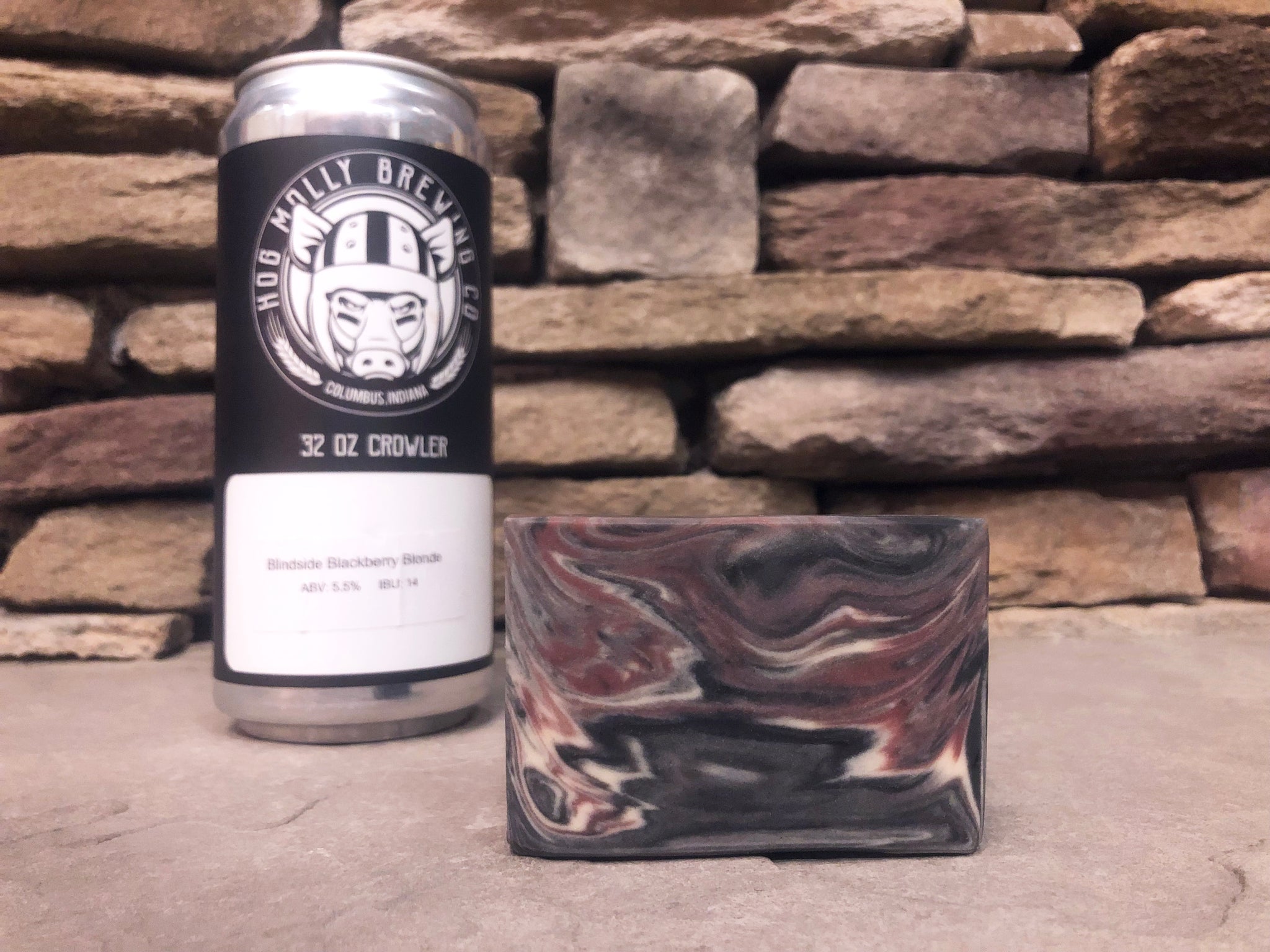 hog Molly brewing co. Beer can crowler beside a marbled beer soap bar made with activated charcoal on a stone surface