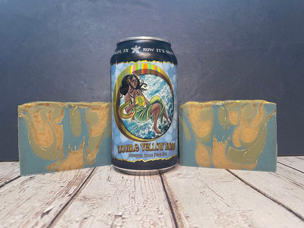 Can of double Yellow Rose beer with two pieces of Yellow Rose beer soap on a wooden surface.