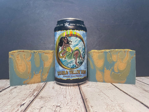 Can of double Yellow Rose beer with two pieces of Yellow Rose beer soap on a wooden surface.