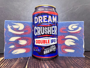 Dream Crusher Double IPA can from Deep Ellum Brewing between two bars of red white and blue beer soap on a wooden surface 