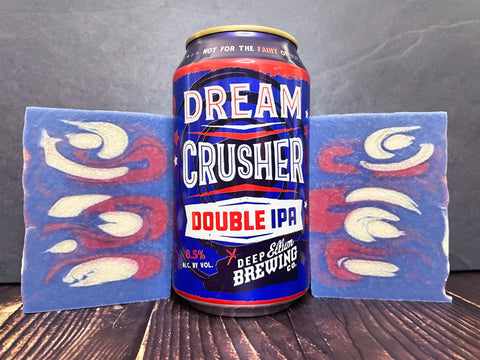 Dream Crusher Double IPA can from Deep Ellum Brewing between two bars of red white and blue beer soap on a wooden surface 