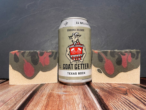 GOAT GETTER TEXAS BOCK 11 below brewing company beer can between two bars of white black grey and red beer soap on a wooden surface with a dark background