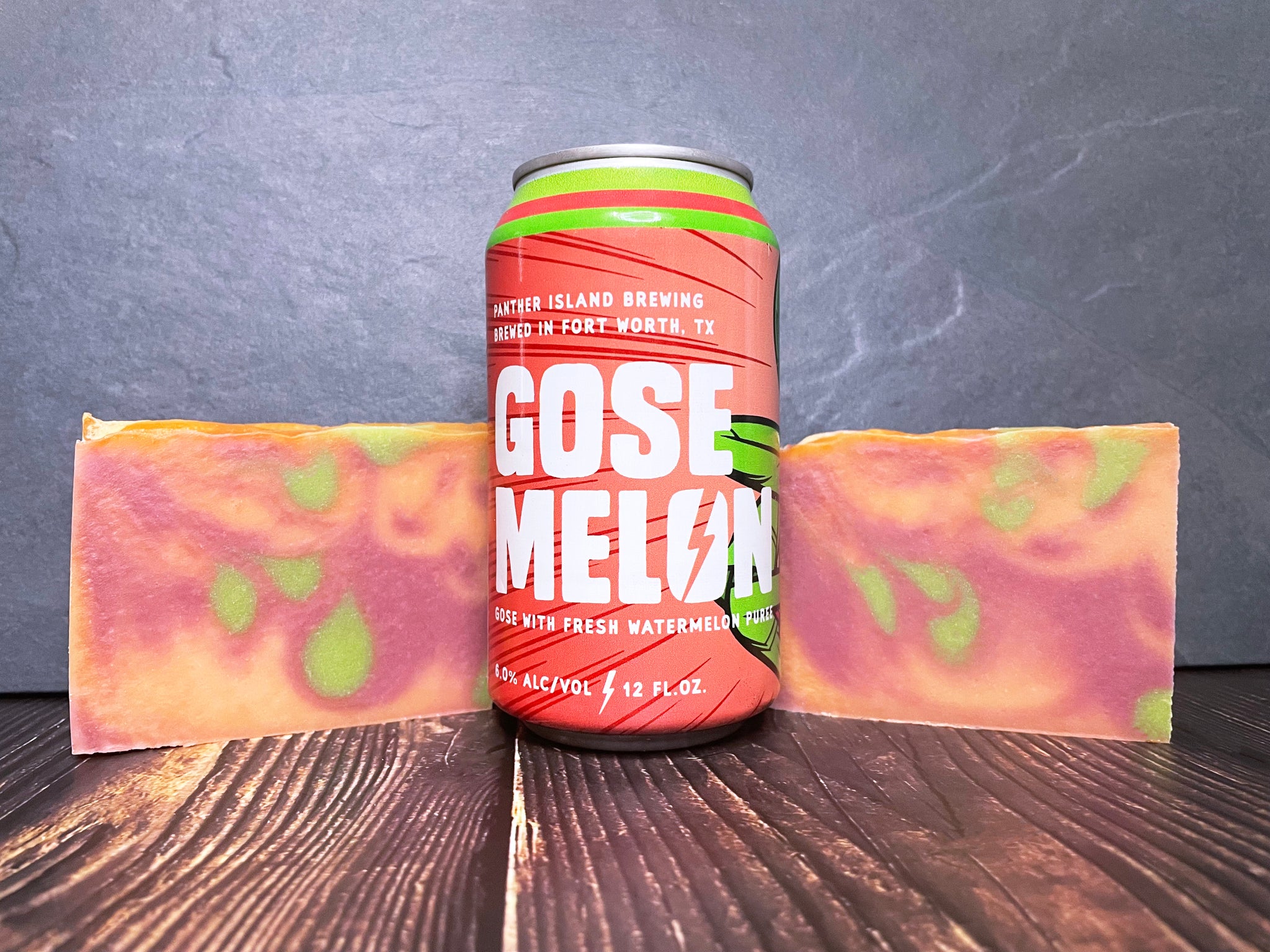 panther island brewing Gose Melon beer can between two marbled green melon and raspberry beer soaps on a wooden surface and dark background