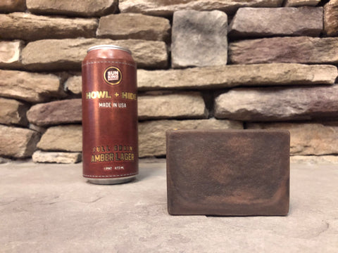 brown beer soap beside a sun king brewery howl and hide amber lager beer can on a stone surface 