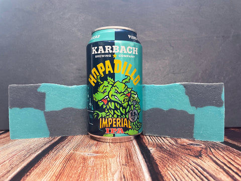 Karbach Brewing Company Hopadillo Imperial IPA can between two bars of hopadillo beer soap on a wooden surface with a gray background