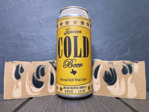 Can of kennimer cold beer by holler brewing company between two bars of gold and black beer soap on wooden surface