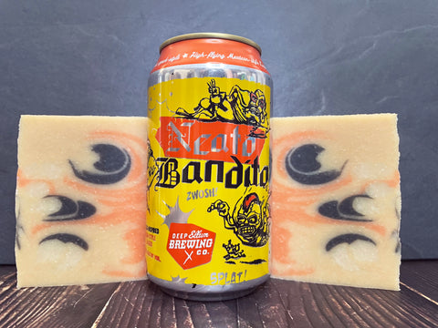 Neato Bandito beer can between deep ellum brewing company beer soap bars on a dark surface