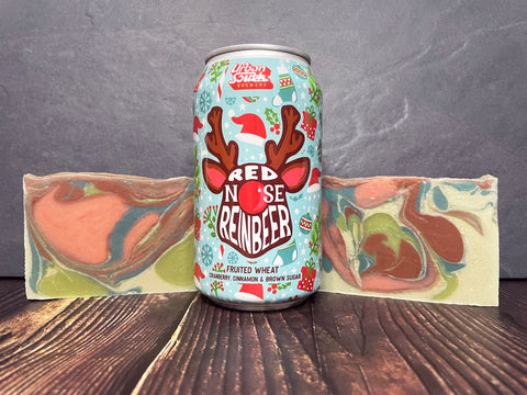 Can urban south brewery Red Nose Reinbeer beer between two bars of beer soap by spunkndisorderly beer soaps on a wooden surface with stone background