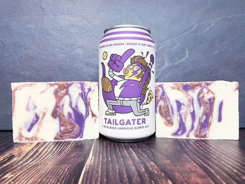 panther island brewing company tailgater American blonde ale beer can between two white brown and purple bars of beer soap on a wooden surface
