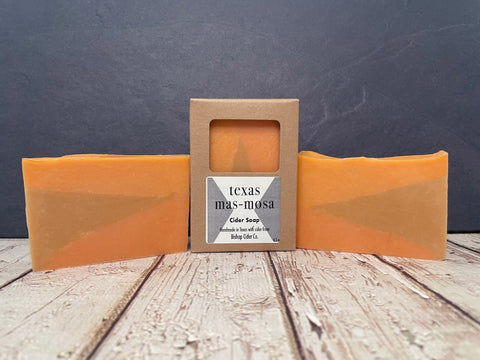 three bars of orange texas masmosa cider soap on a wooden surface with dark background