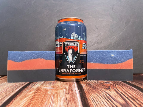 black red and blue beer soap bars beside a starbase brewing can of the terraformer red ale on a wooden surface